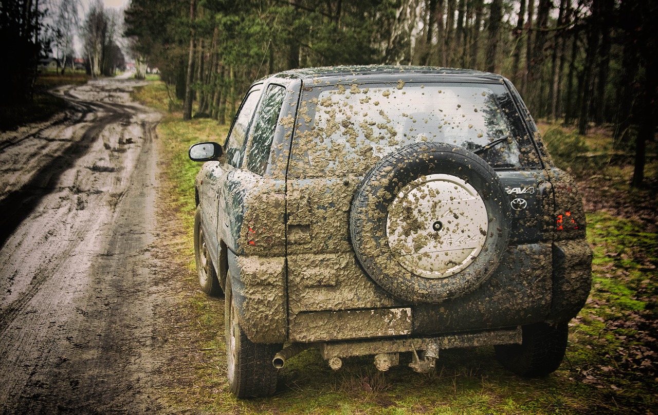 Completely dirty SUV parked on the side of the road